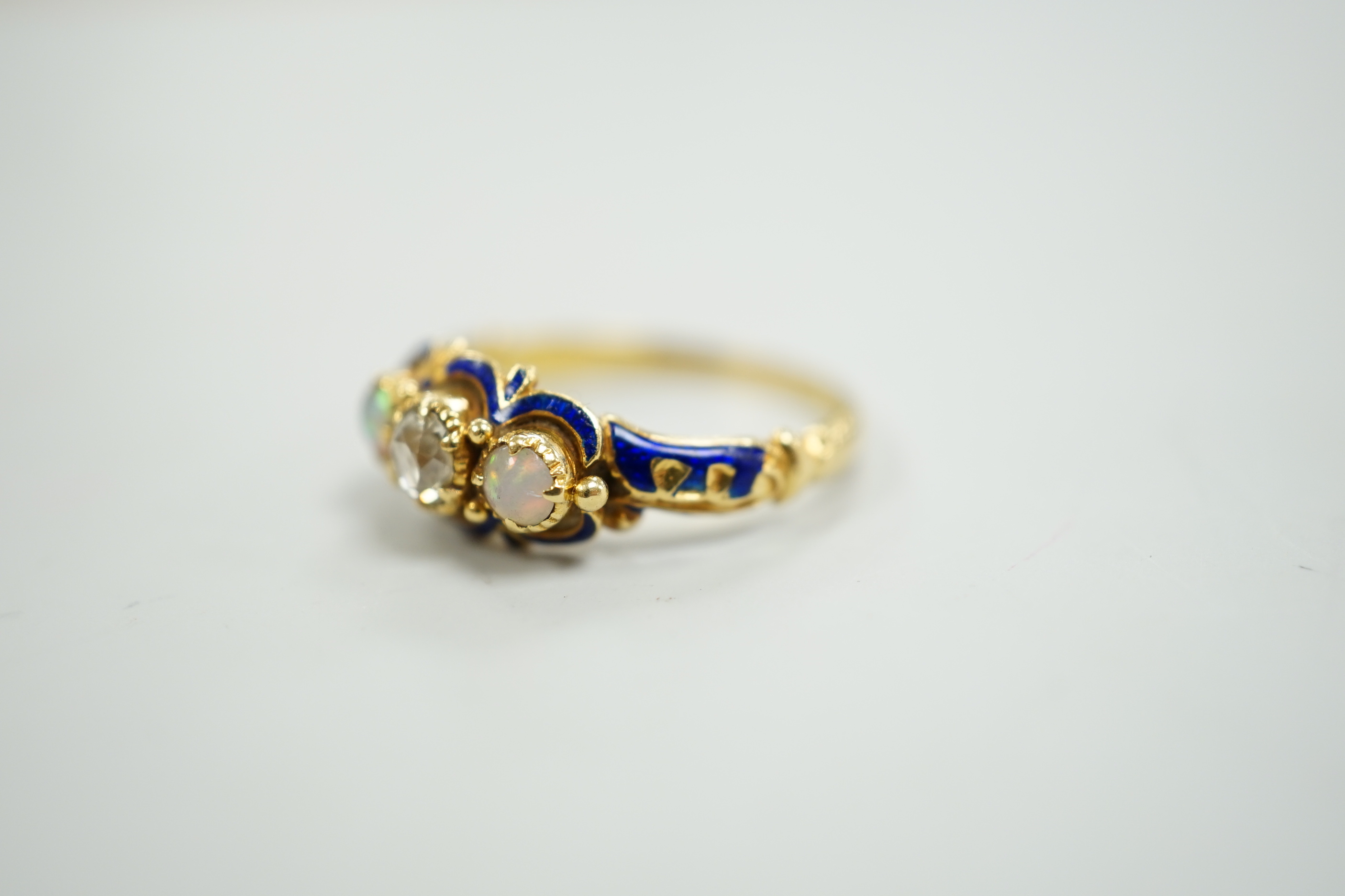 A late Victorian yellow metal, single stone diamond, two stone opal and enamelled dress ring, size K, gross weight 3 grams.